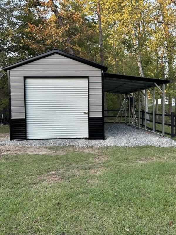Front of a gray metal garage with a roll-up door and an open lean-to on the side